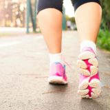photo of woman wearing pink sports shoes walking