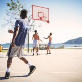 four people playing basketball